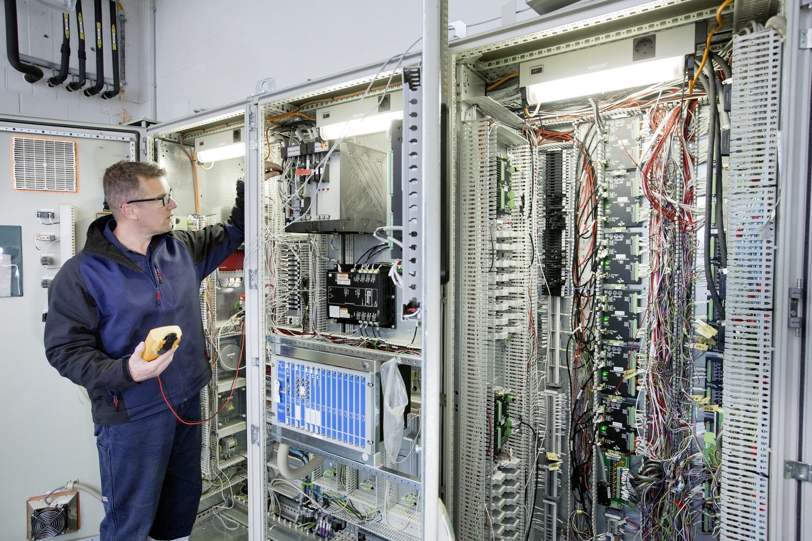 Remco Petersen with a multimeter at an open turbine control cabinet